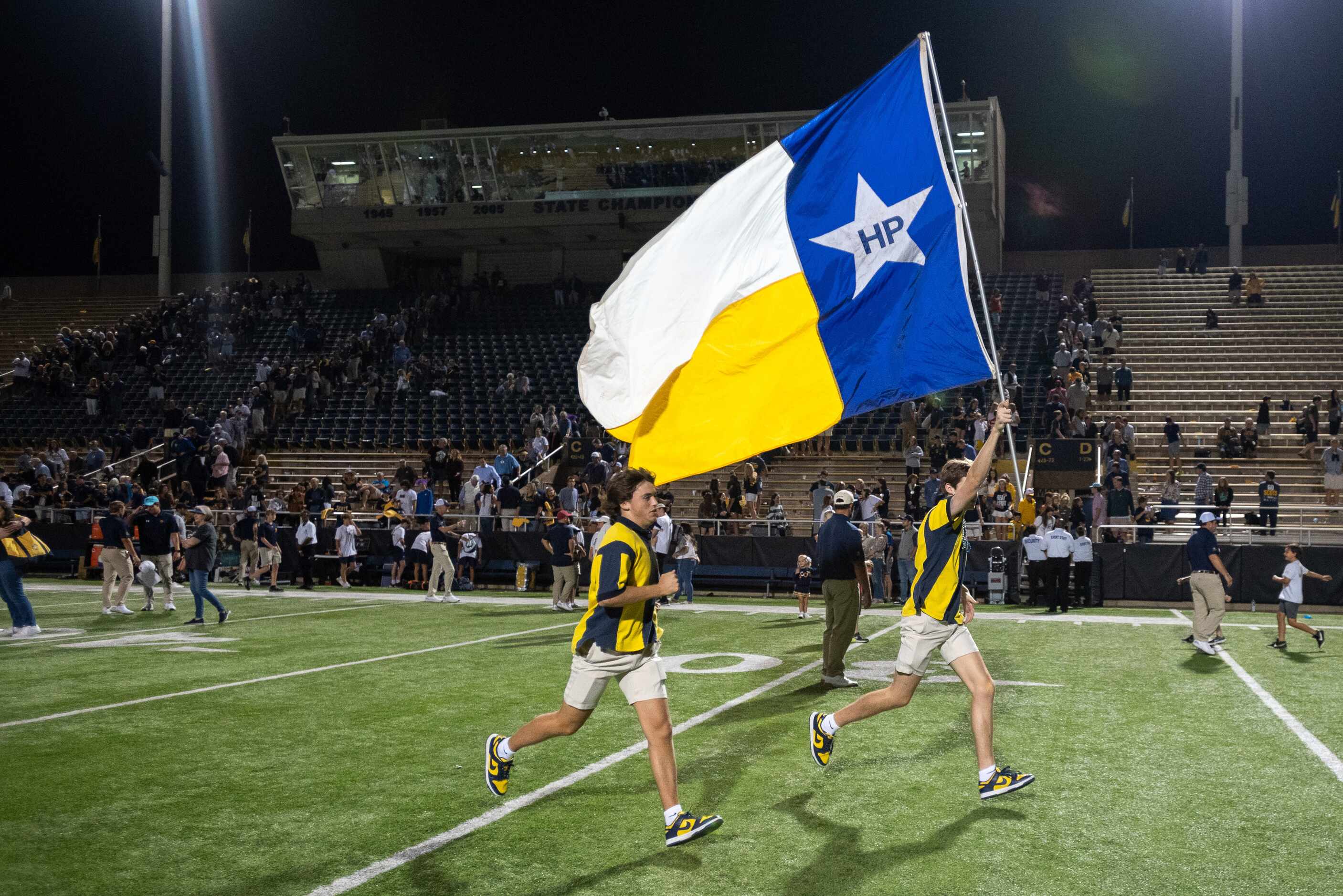Highland Park students wave the HP flag as they celebrate a victory over Jesuit 35 to 28 at...