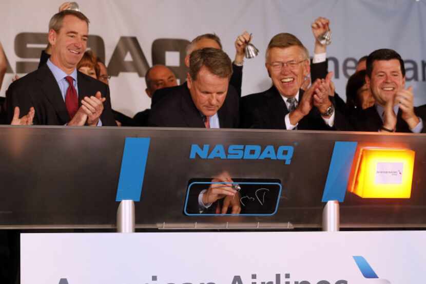 Doug Parker (center), CEO of the new American Airlines, rang the opening bell for Nasdaq...