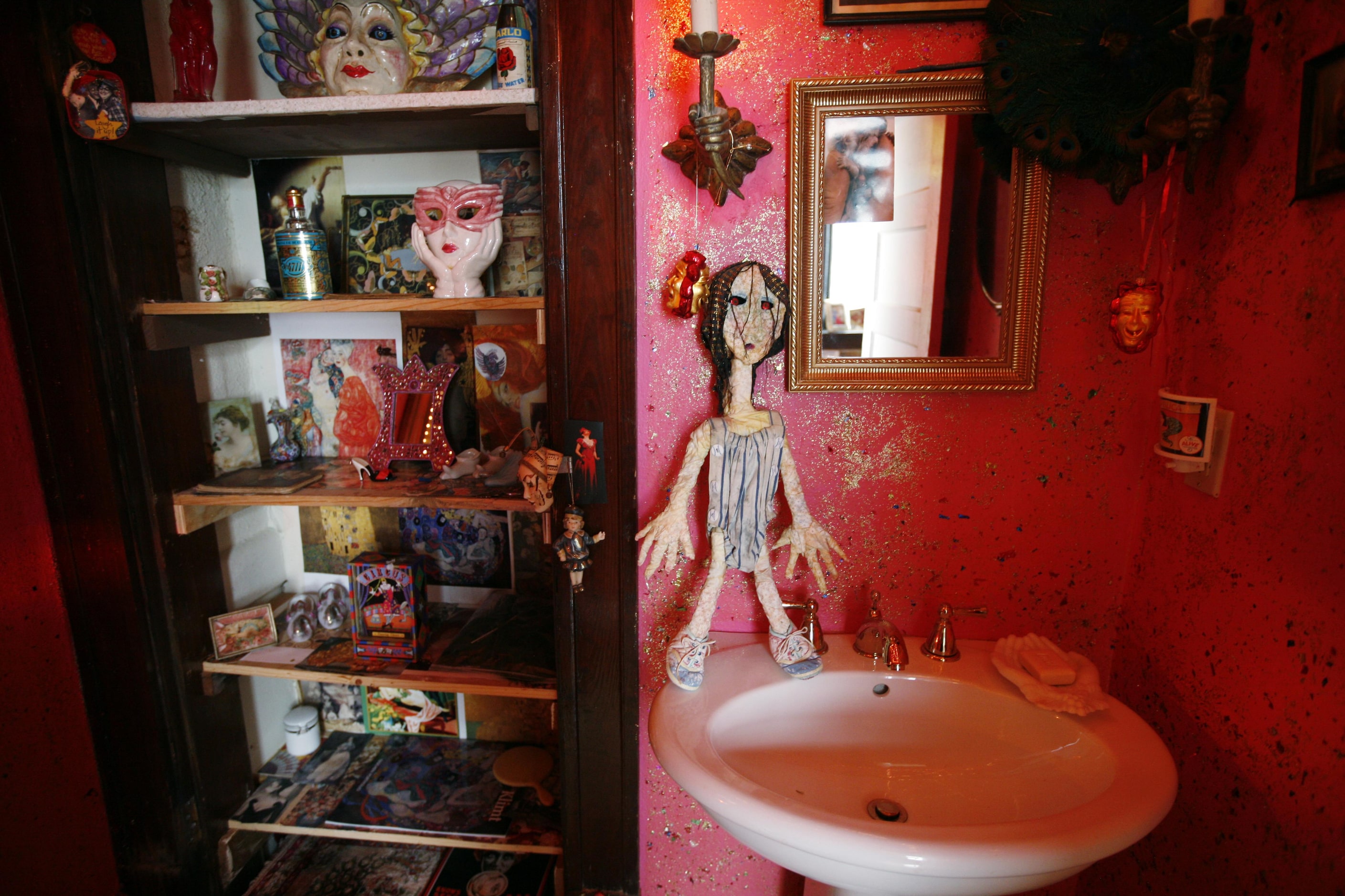 The guest powder room sparkled with glitter-painted walls, playful masks and art by Edward...