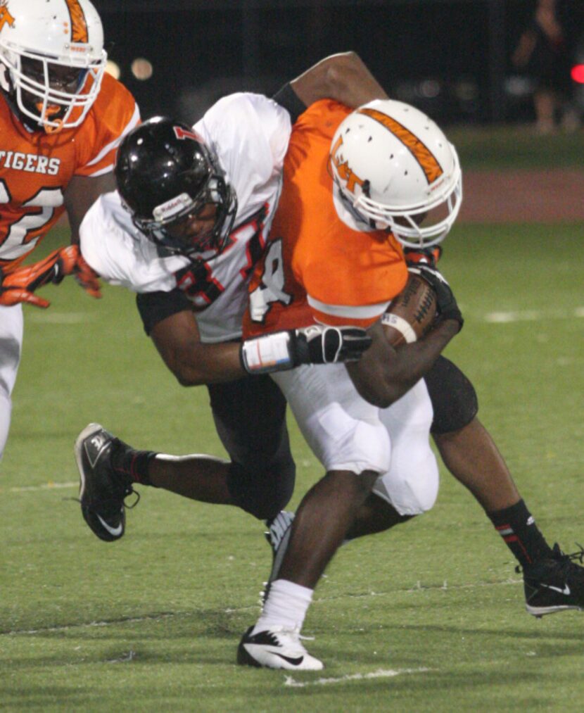 Lancaster senior running back Joseph Paden (24, right) is tackled by Mansfield Legacy junior...