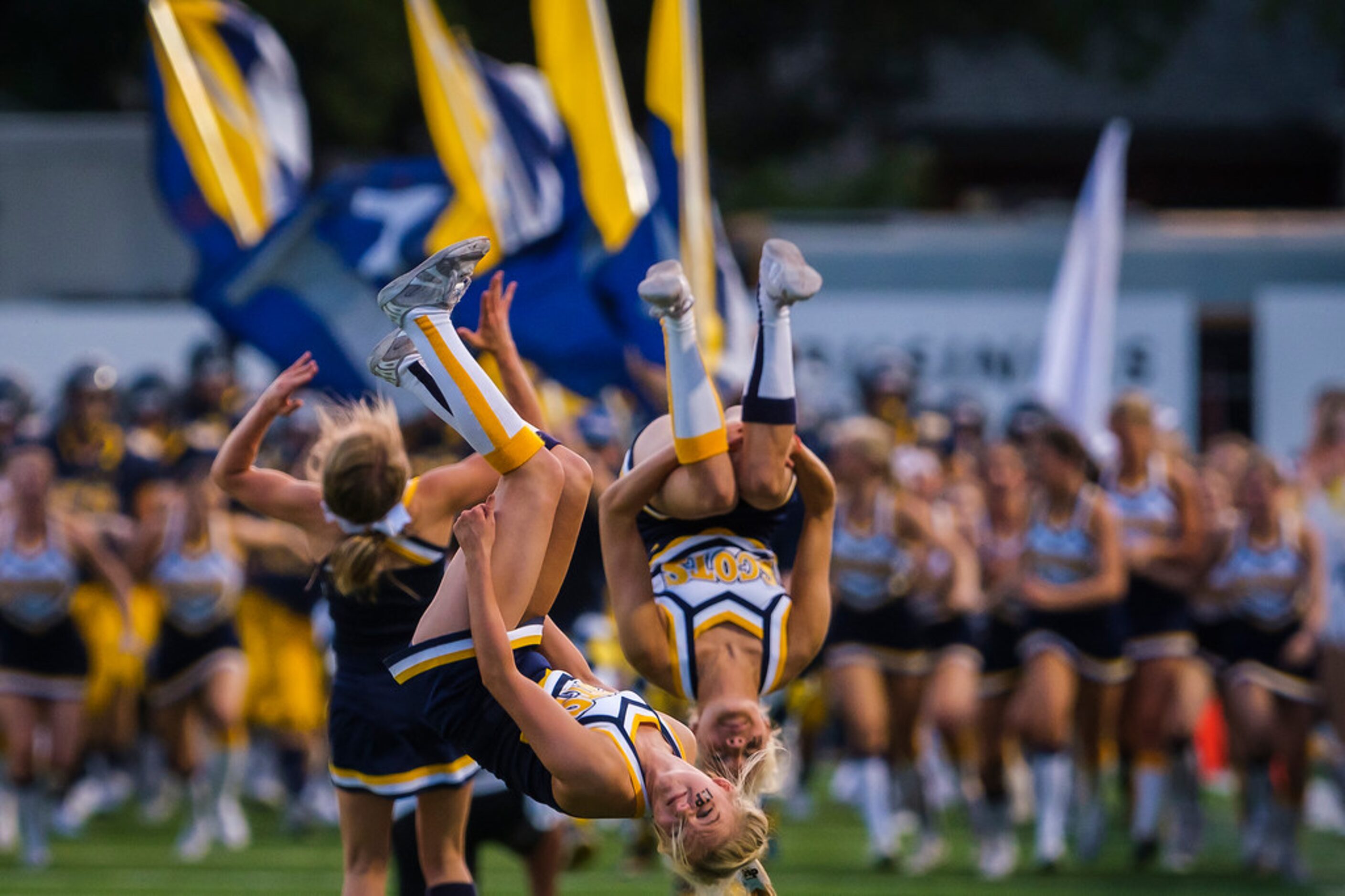 Highland Park cheerleaders lead their team onto the field for a high school football game...