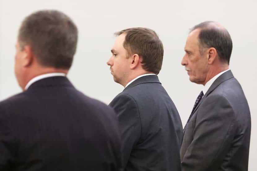 Aaron Dean, center, stands with his defense team as Judge George Gallagher reads his...