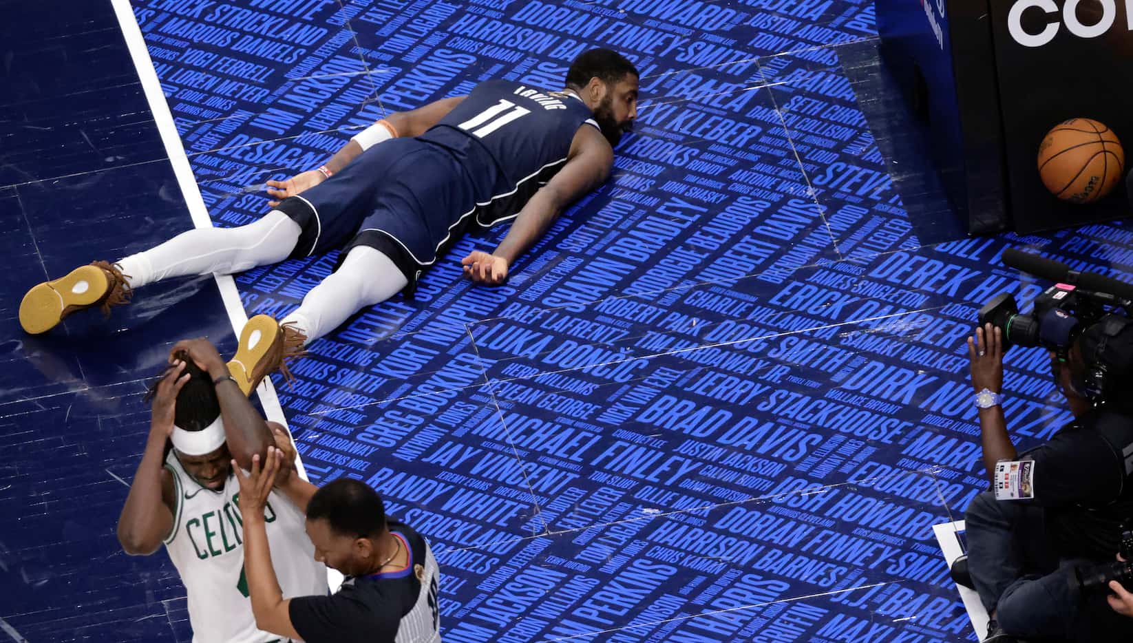 Dallas Mavericks guard Kyrie Irving (11) lies flat on the floor after being fouled by Boston...