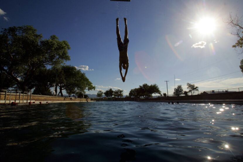 A swimmer dives into the spring-fed swimming pool at Balmorhea State Park in Toyahvale,...