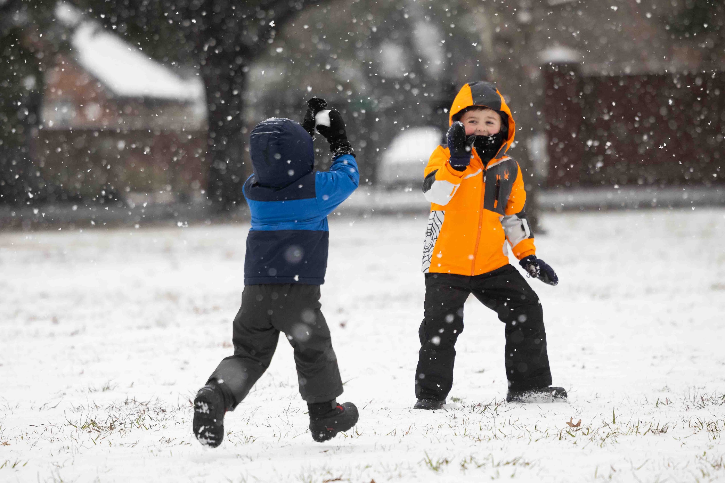 Ryan Talman, 2, chases brother Luke Talman, 4, with a snowball at Frankford Park in Dallas...