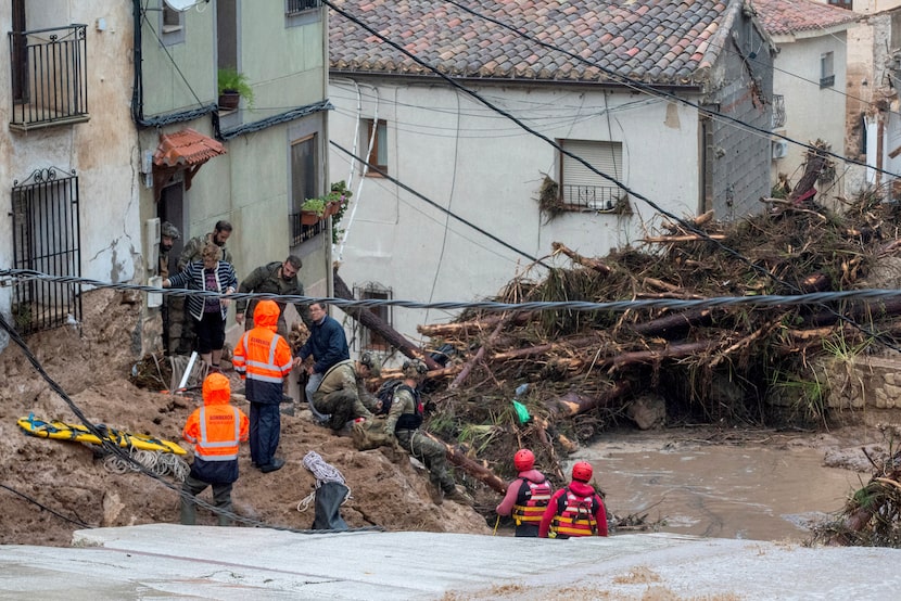 Miembros del Ejército español y servicios de emergencia rescatan a personas atrapadas en sus...