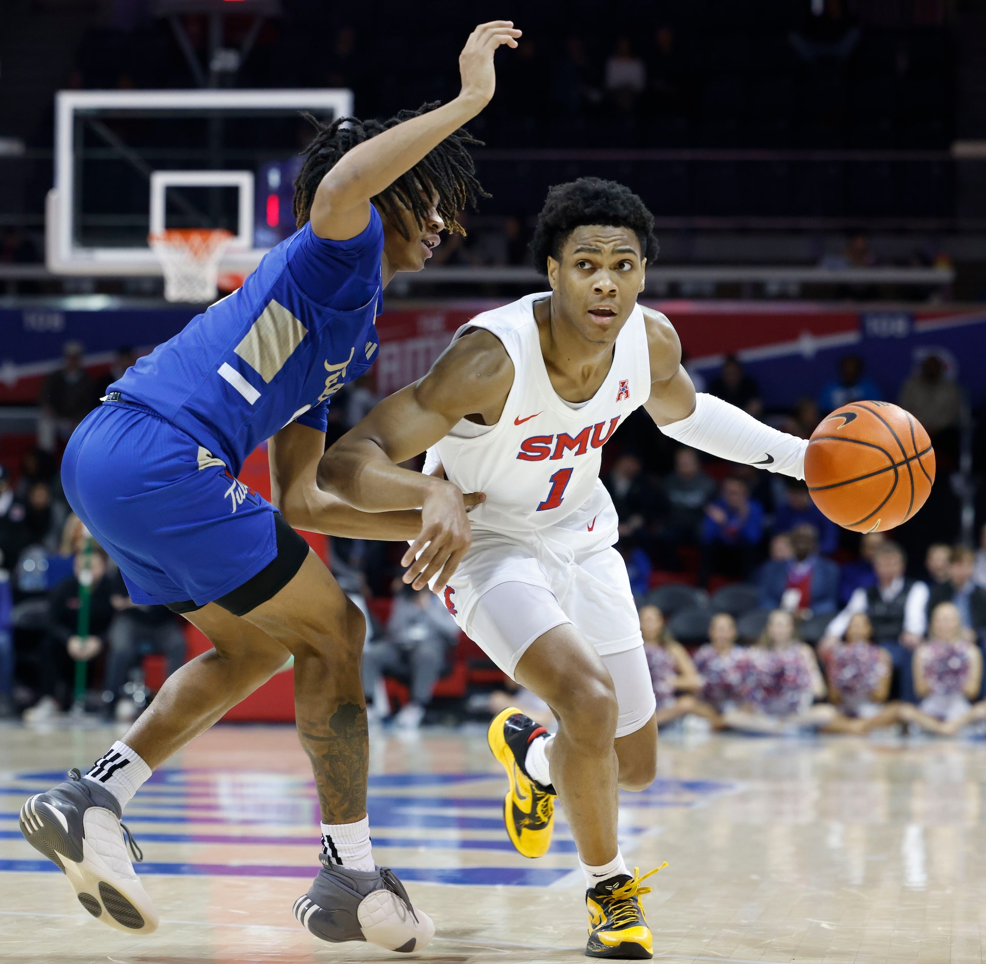 Southern Methodist guard Zhuric Phelps (right) dribbles past Tulsa guard Tyshawn Archie...