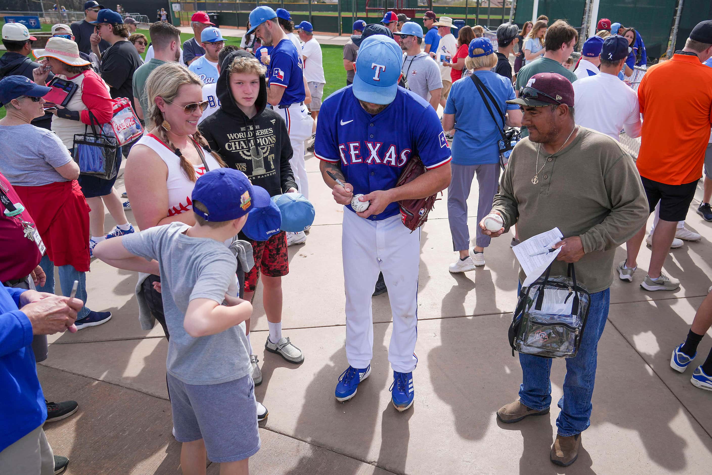 Texas Rangers pitcher Danny Duffy signs autographs during a spring training workout at the...