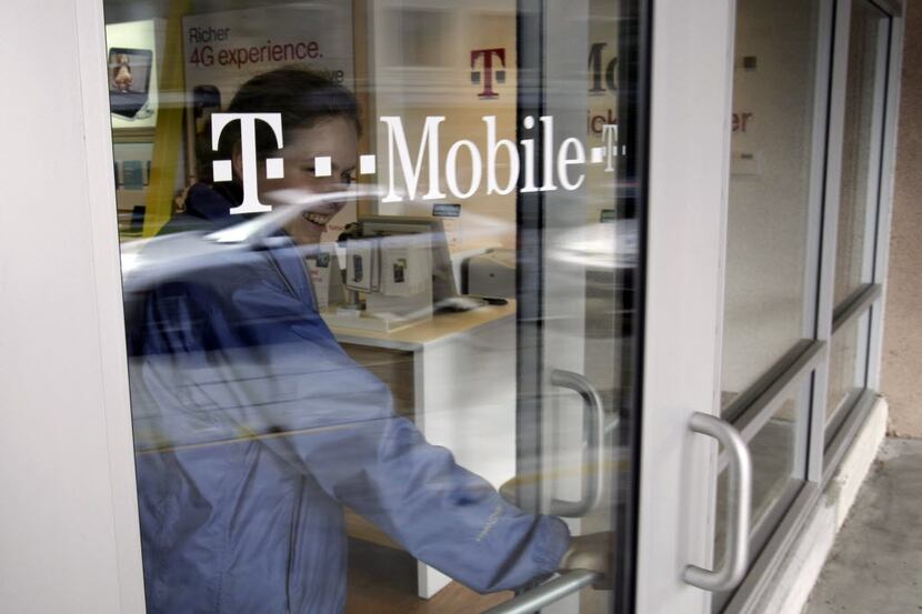 A customer walks out of a T-Mobile store in Palo Alto, Calif., Friday, Feb. 25, 2011....