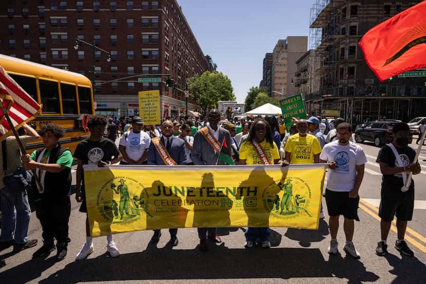 Personas marchan para celebrar Juneteenth el 15 de junio de 2024 en el barrio Harlem de...