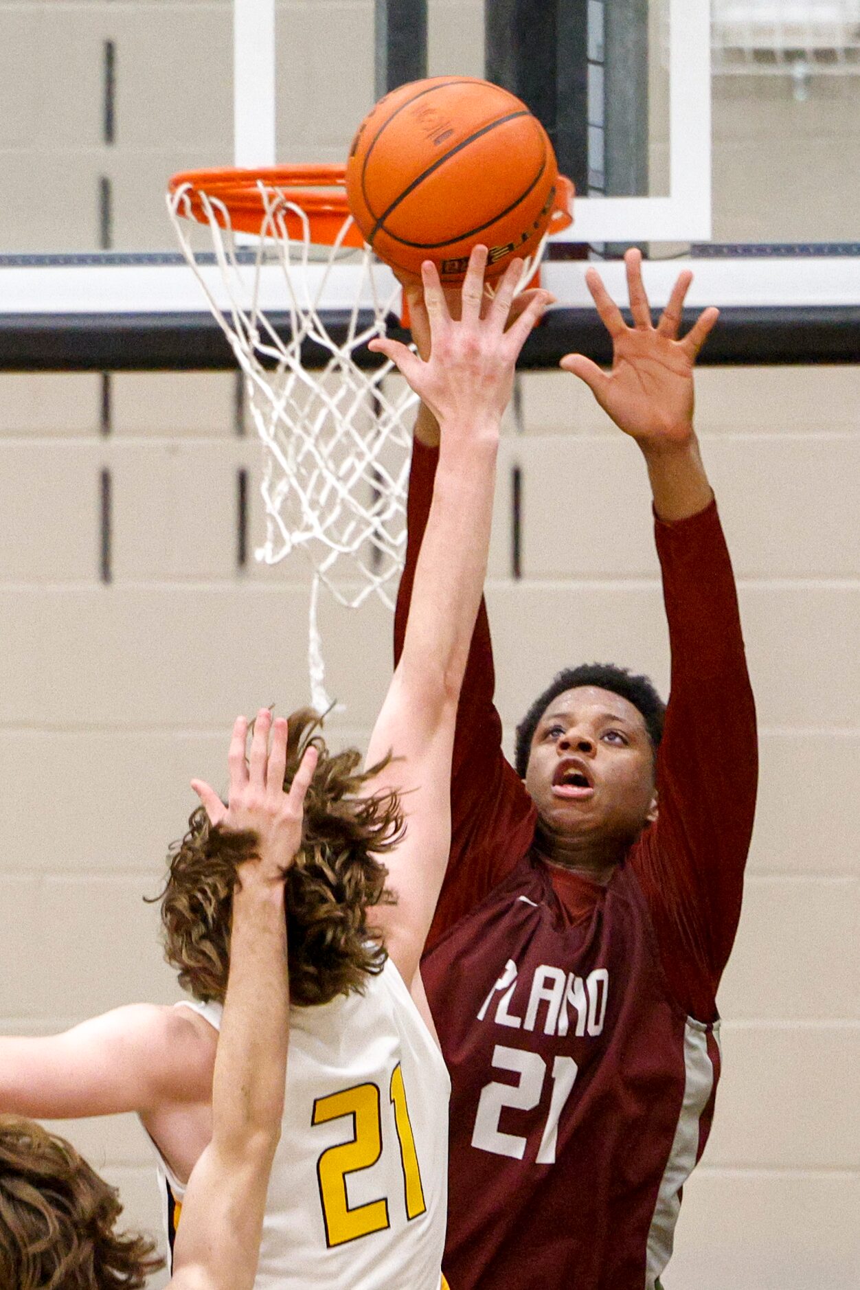 Plano forward Justin McBride (21) blocks a layup from Frisco Memorial Drew Steffe (21)...