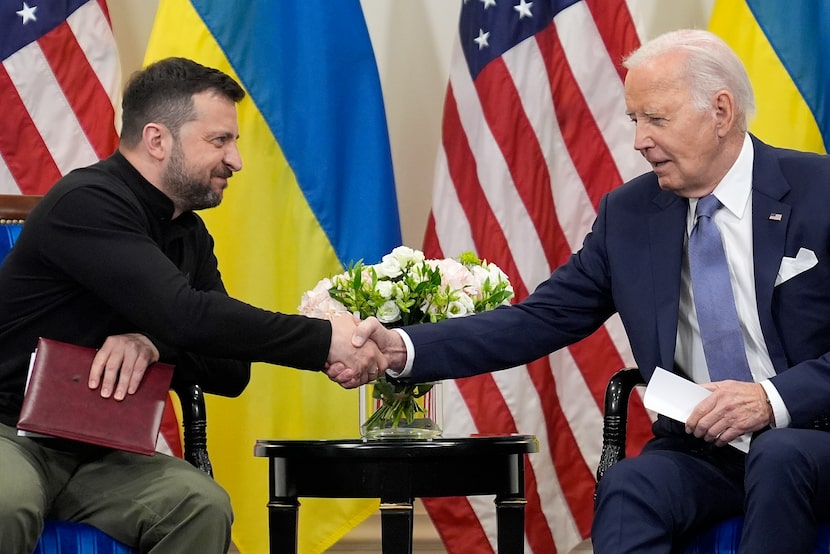 U.S. President Joe Biden shakes hands with Ukrainian President Volodymyr Zelenskyy in Paris,...