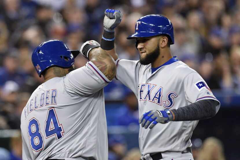 Texas Rangers' Nomar Mazara, right, celebrates with teammate Prince Fielder after hitting a...