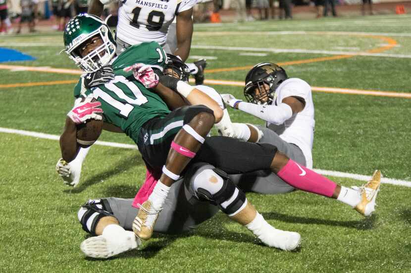 Arlington wide receiver Trey Cleveland (10) pushes forward for extra yards during a high...