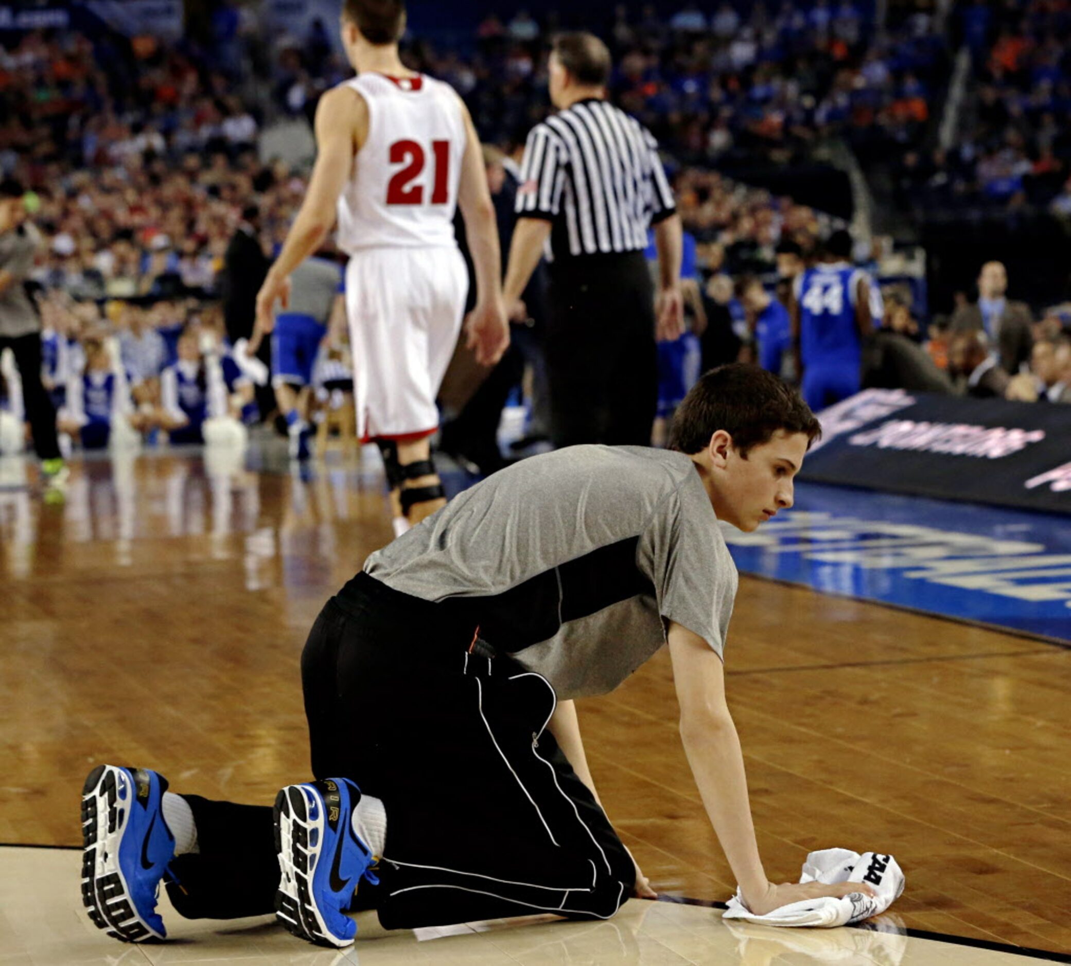 A ball kid mops up sweat during the first half of Wisconsin Badgers game against Kentucky...