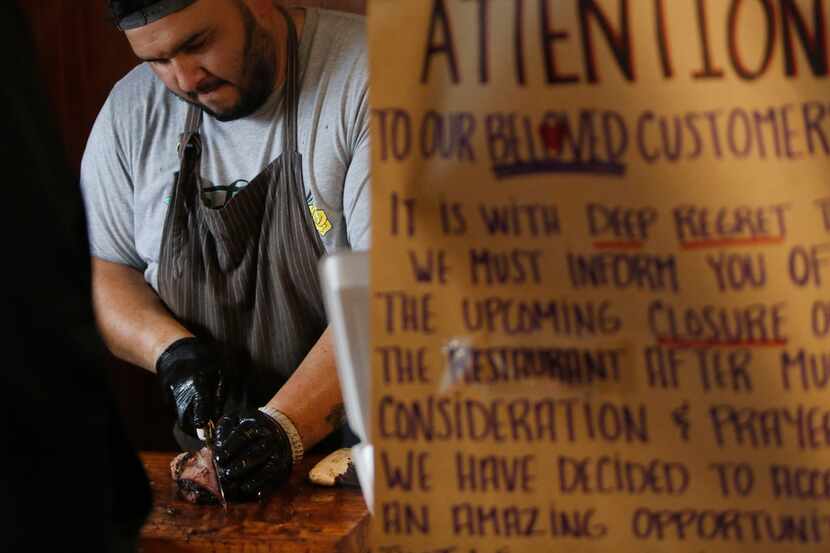 Michael Wyont, pitmaster and owner of Flores Barbecue, slices brisket on its final weekend...