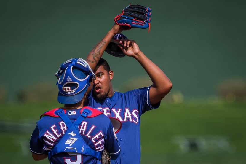 Texas Rangers pitcher Yohander Mndez gets a visit fromn catcher Isiah Kiner-Falefa after...