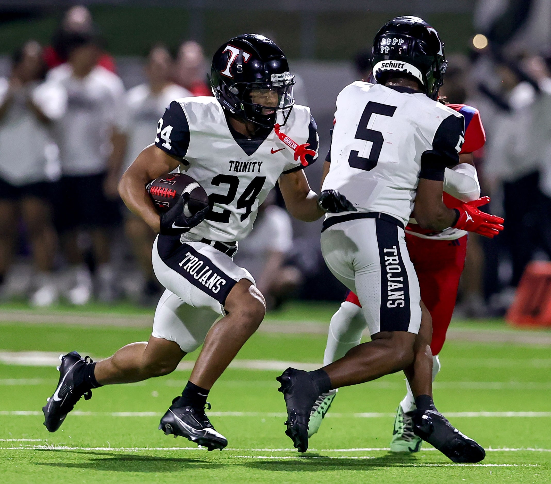 Trinity running back JT Harris (24) follows a block by wide receiver Ethan Wright (5) for a...