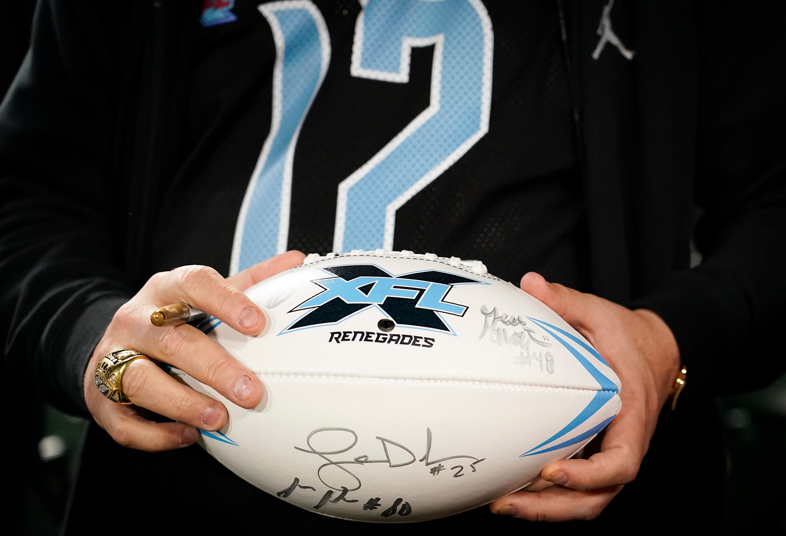 A Dallas Renegades fan holds a football while seeking autographs from players after a loss...