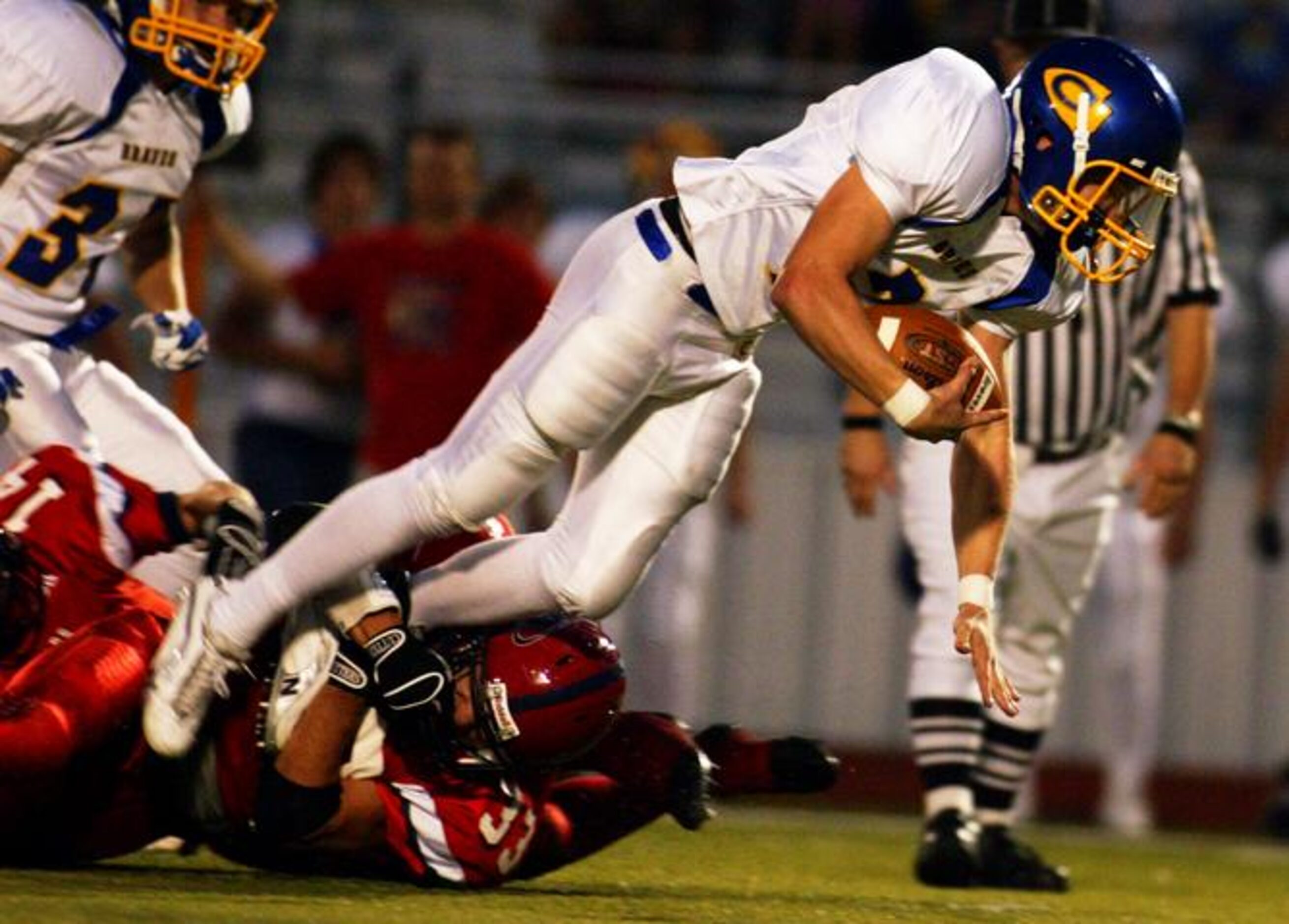 Nevada Community sophomore quarterback Collin Strahan (2) is tackled by Aubrey's Justin...