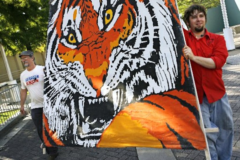 Jeffrey Jacoby (right) and Johnny Wolf of Crawford walk a large sign toward the Morton H....