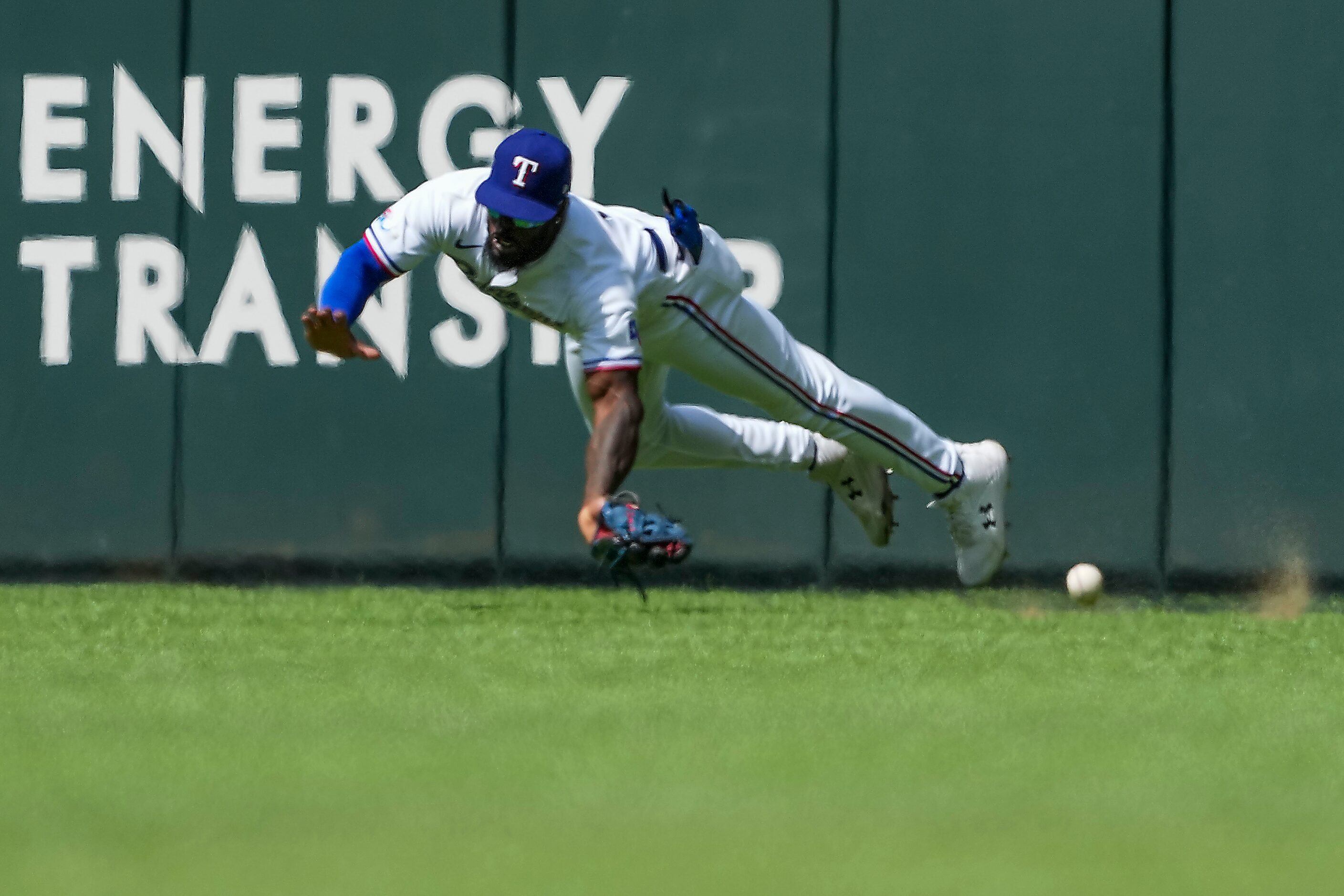 Texas Rangers center fielder Adolis Garcia can’t make the play on a triple off the bat of...