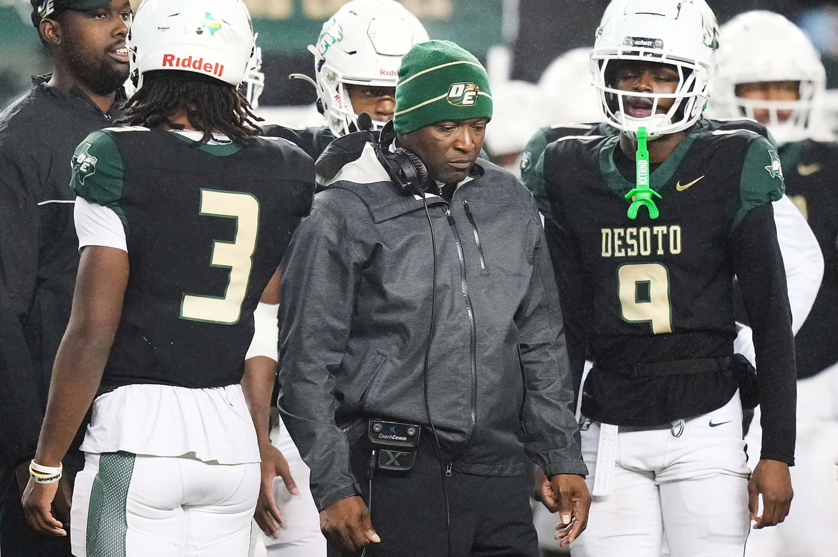 DeSoto head coach Claude Mathis talks with quarterback Kelden Ryan (3) and wide receiver...