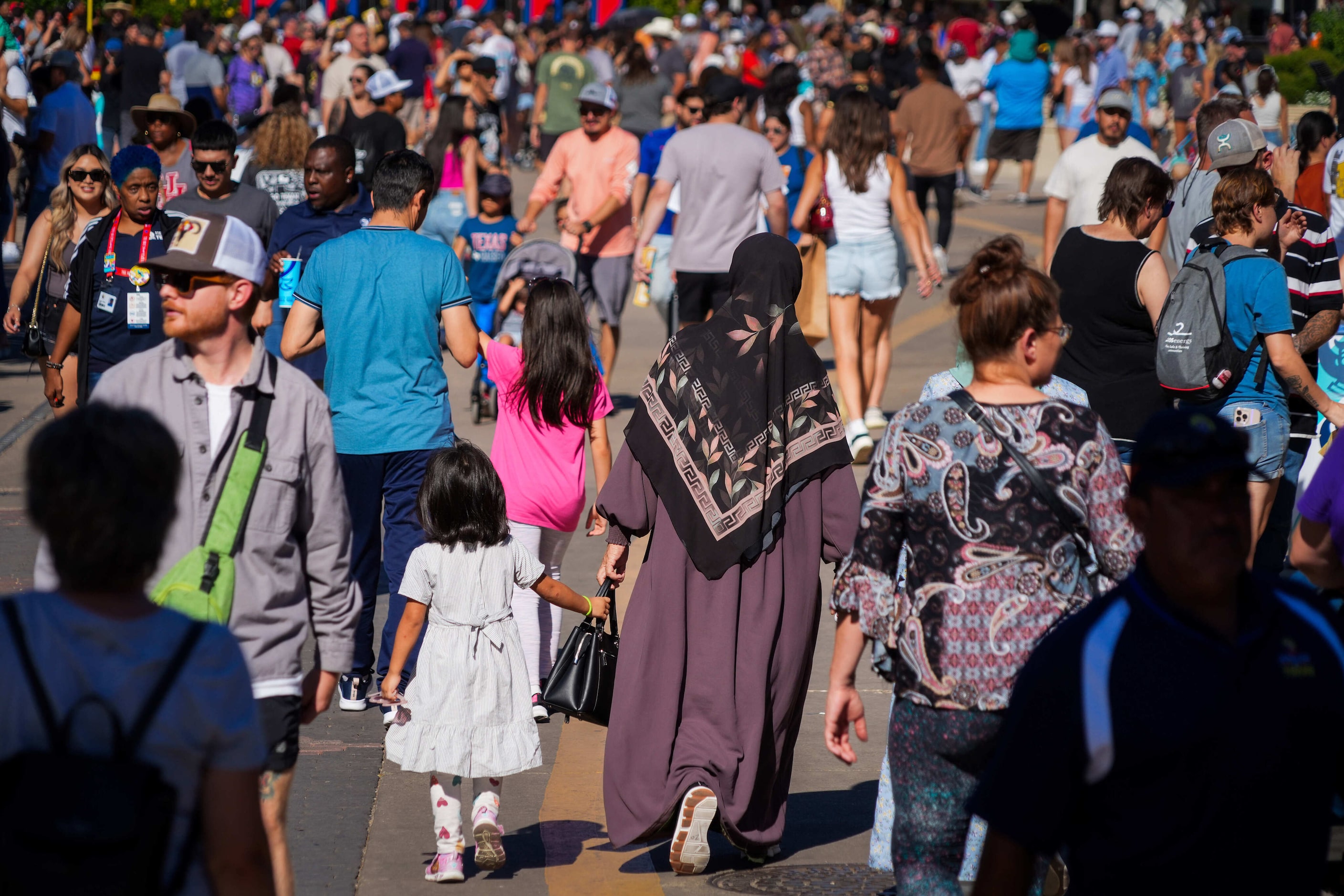 Fairgoers walk along Grand Avenue at the State Fair of Texas on Sunday, Sept. 29, 2024, in...