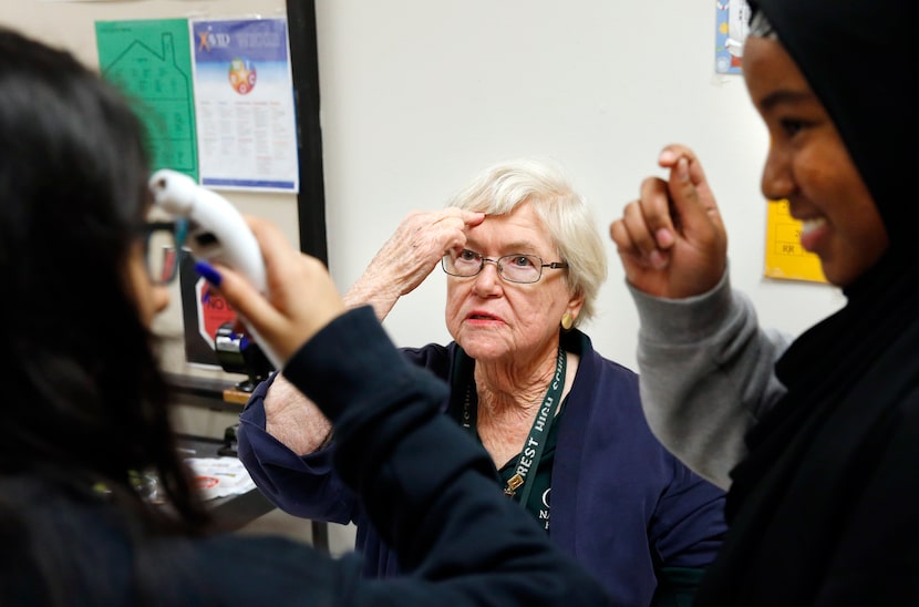 Sharon Bradley shows sophomores Benizia Olmeda, left and Kathija Ogunlende how to use a...