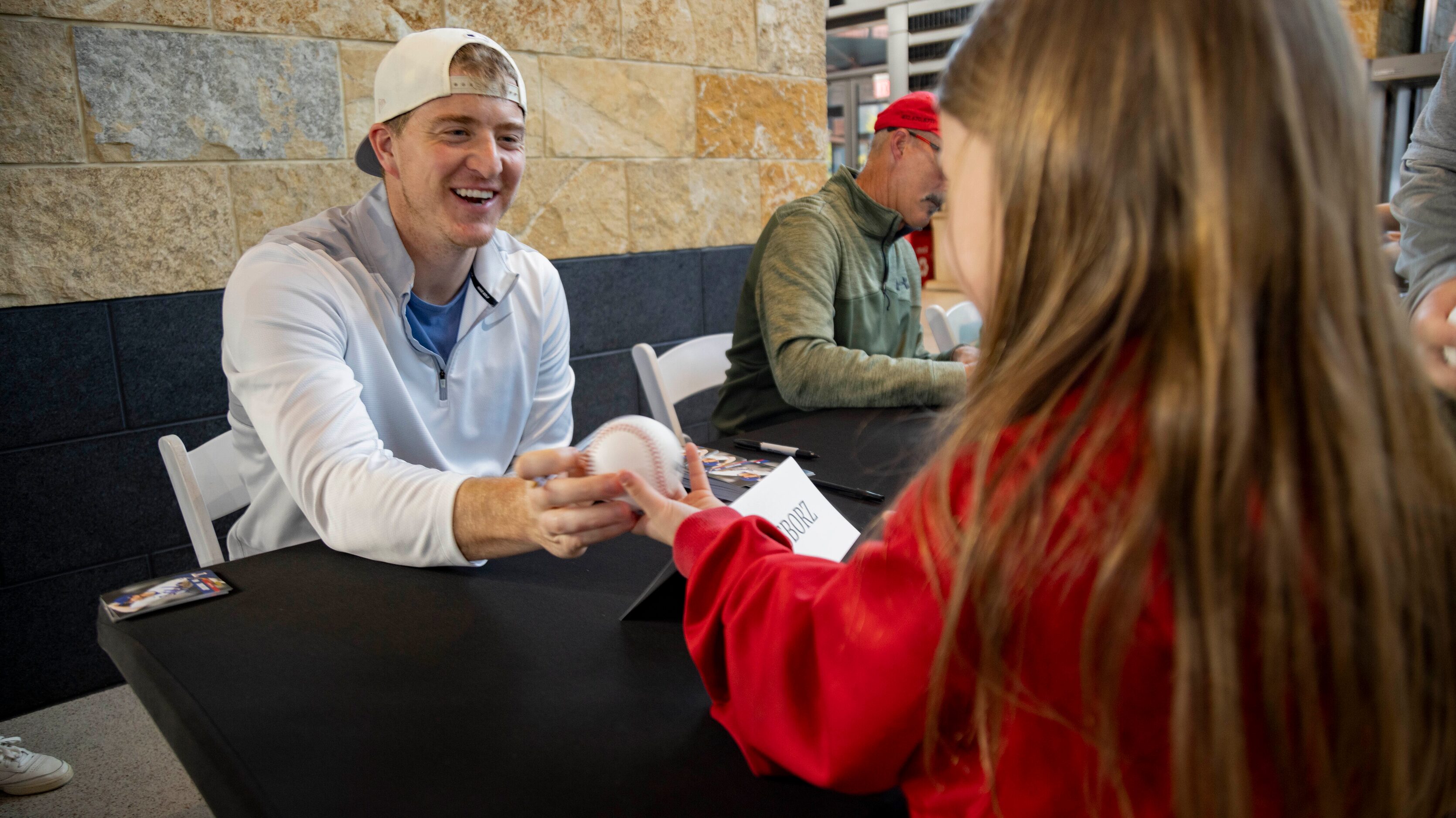 Texas Rangers relief pitcher Josh Sborz (66) smiles as he hands Zoey Rice’s, 6, ball back...