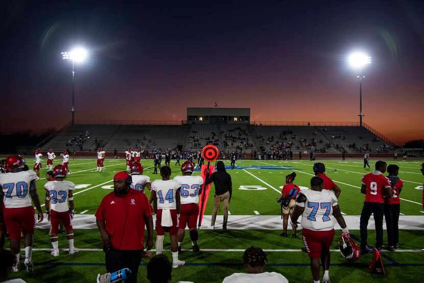 Carter players watch the game from the sideline during a high school football game between...