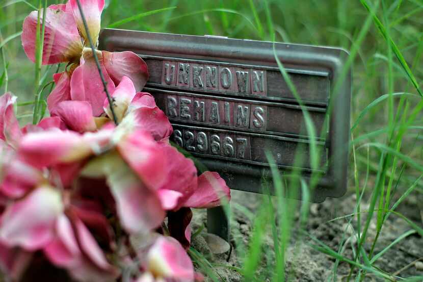 In this Aug. 23, 2013, photo, a small sign at a cemetery marks the grave site of an...