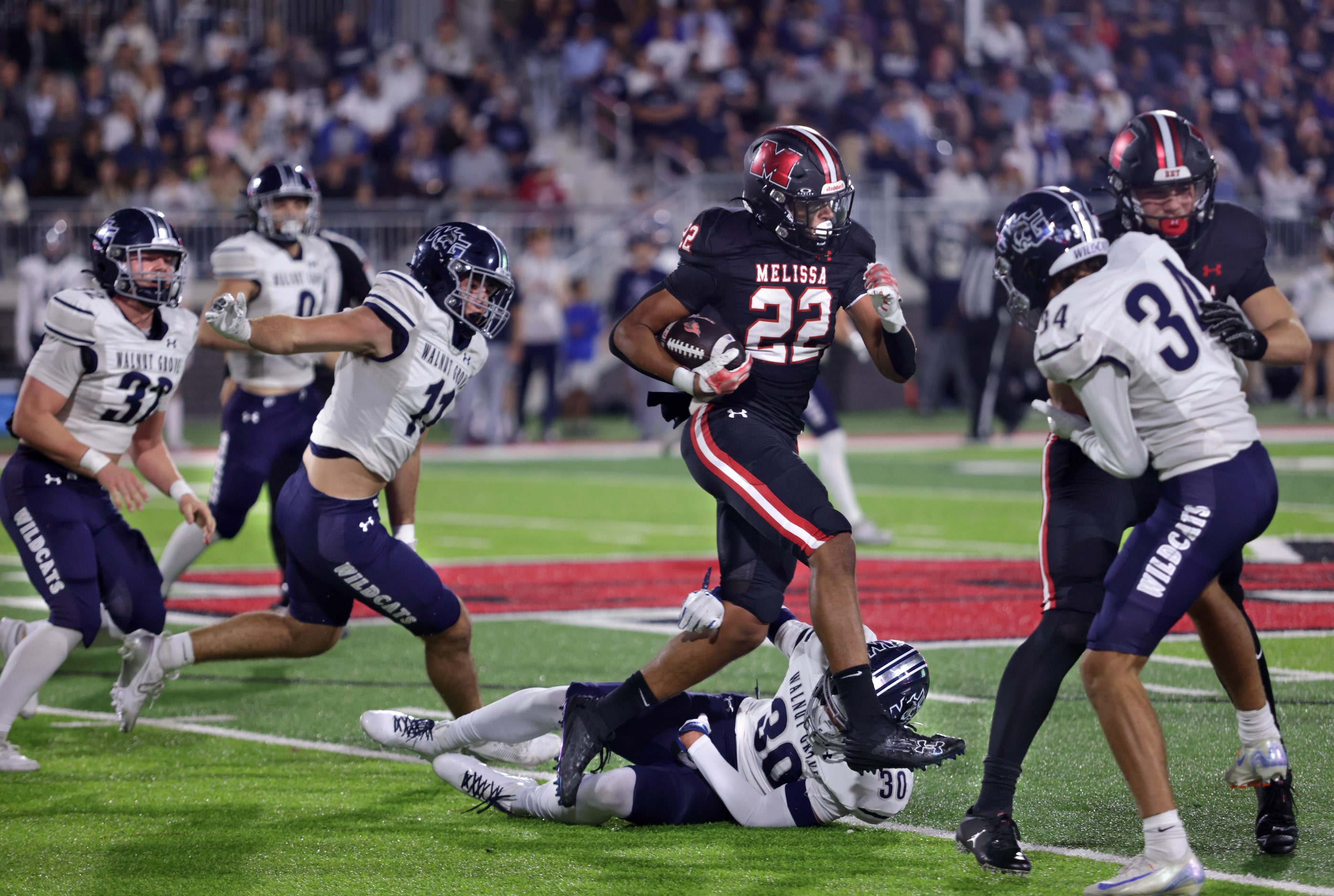 Melissa player #22 Jeremiah Tabor attempts to run past Walnut Grove player #30 Tony...