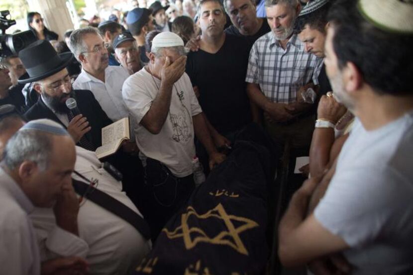 
Relatives of Dror Khenin grieve Wednesday during his funeral in Yehud, east of Tel Aviv,...