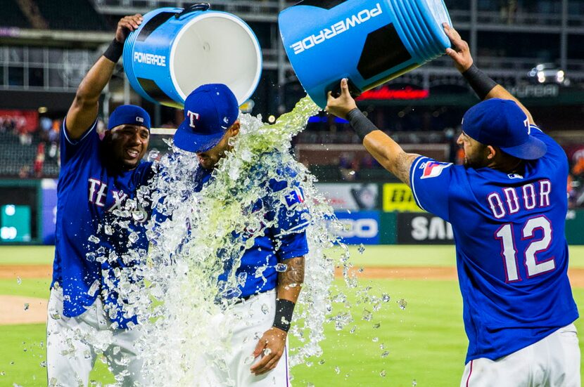 Texas Rangers center fielder Ian Desmond (20) is doused by Gatorade by shortstop Elvis...