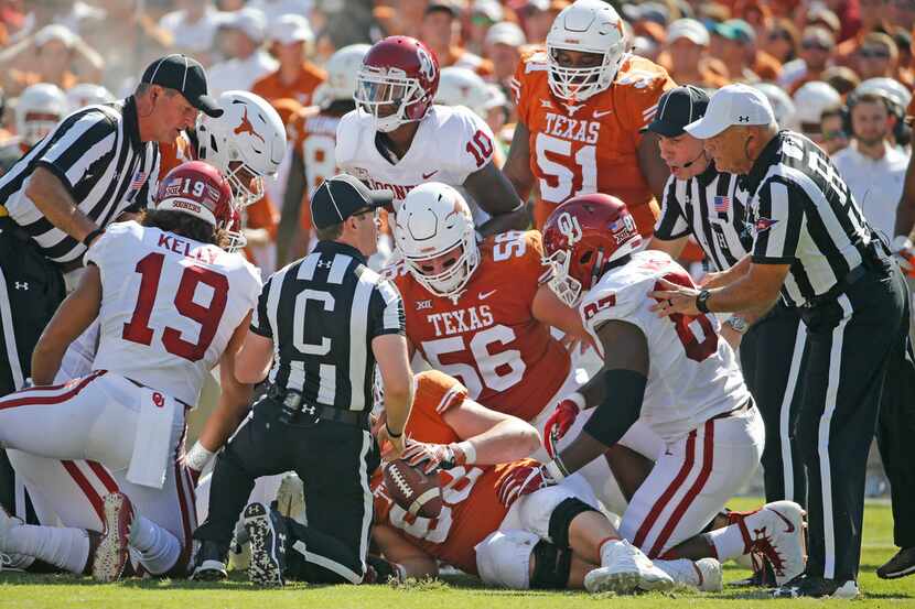 The officials try to determine possession after a first-quarter fumble during the Oklahoma...