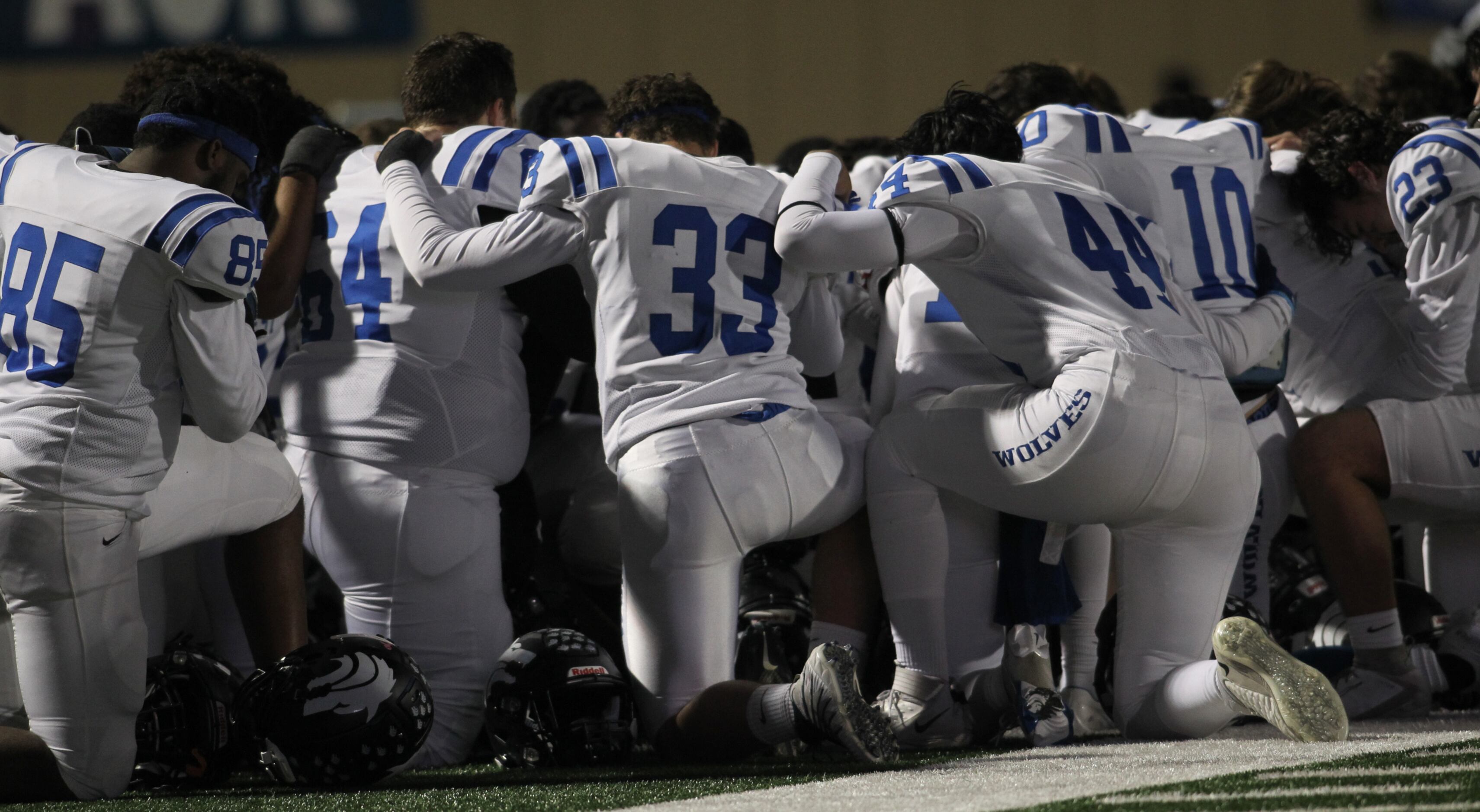 Plano West Wolves huddle near the team's bench area while medical personnel assist Wolves...