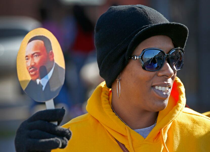 Latrici Hines holds a Martin Luther King, Jr., photo while watching a MLK Day parade in...