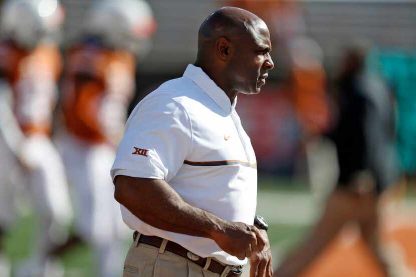 Texas Longhorns coach Charlie Strong watches his team during warm ups against West Virginia...