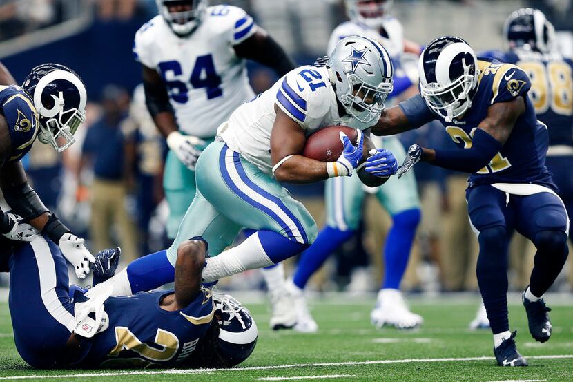 Dallas Cowboys running back Ezekiel Elliott (21) is tackled by Los Angeles Rams inside...