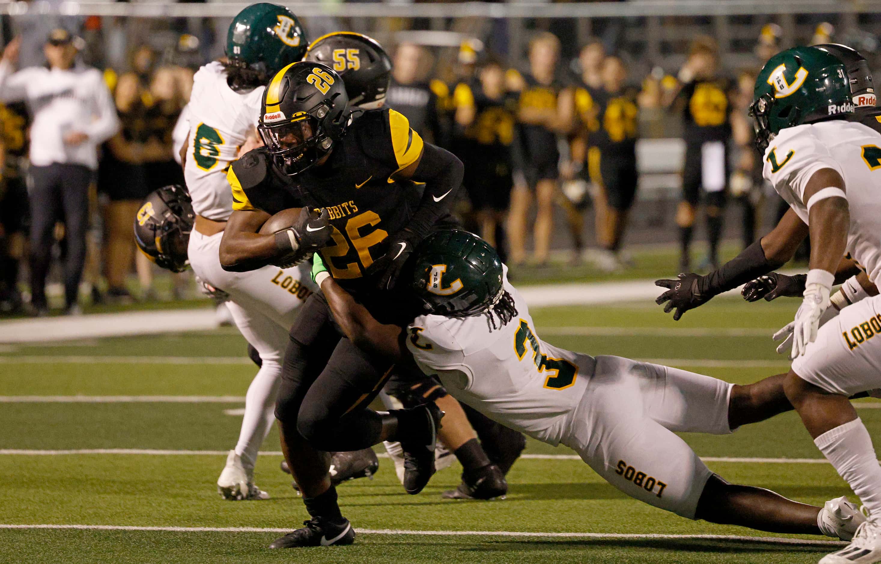 Forney's Javian Osborne (26) is tackled by Longview's Chase Smith (3) during the second half...