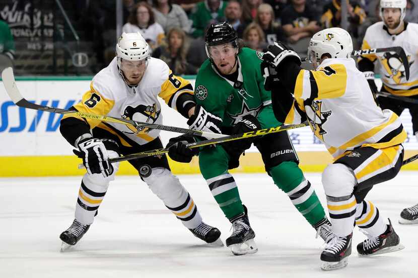 Pittsburgh Penguins defenseman Jamie Oleksiak (6) and Conor Sheary, right, combine to strip...