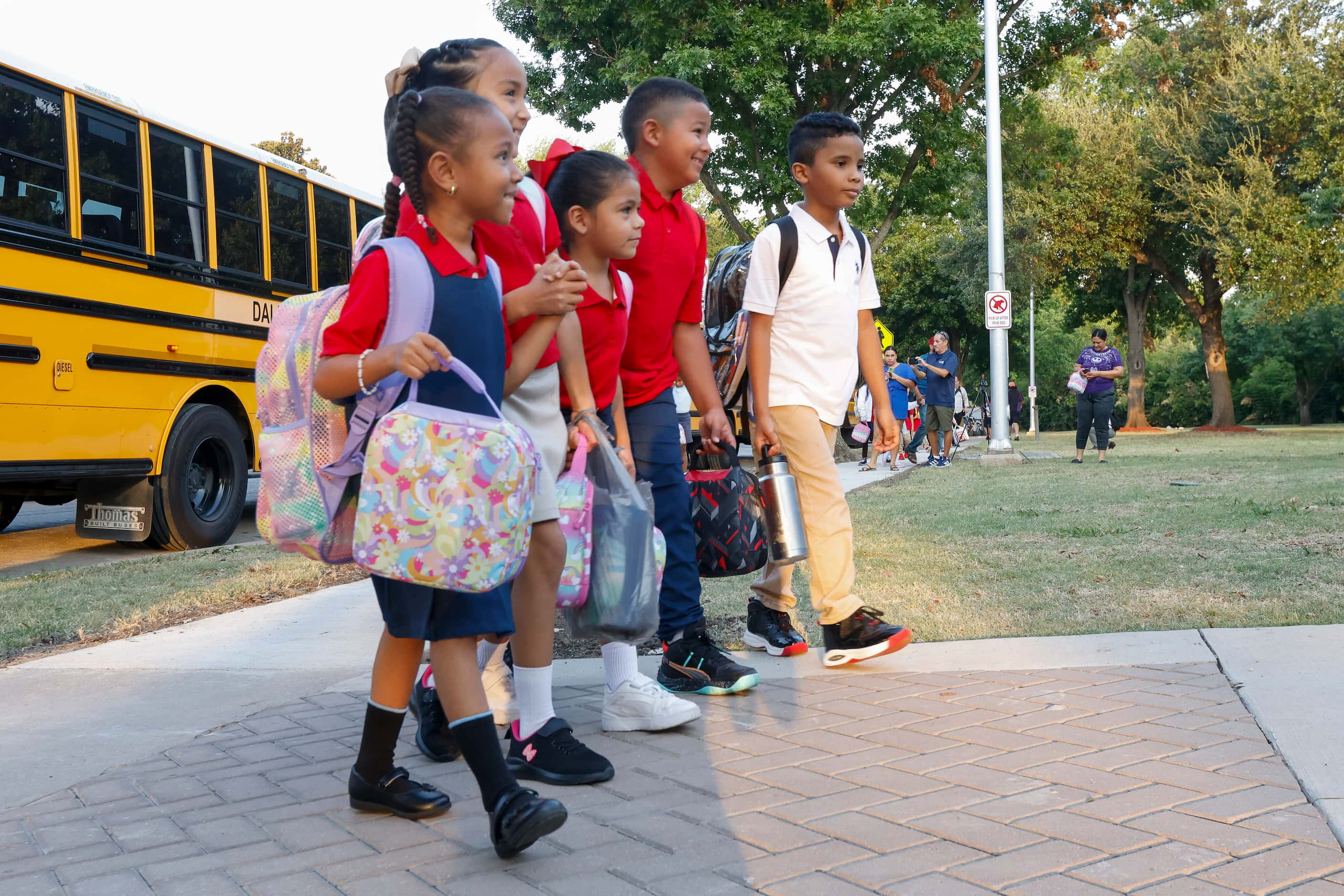 A group of students walk to John J. Pershing Elementary School for the first day of classes,...