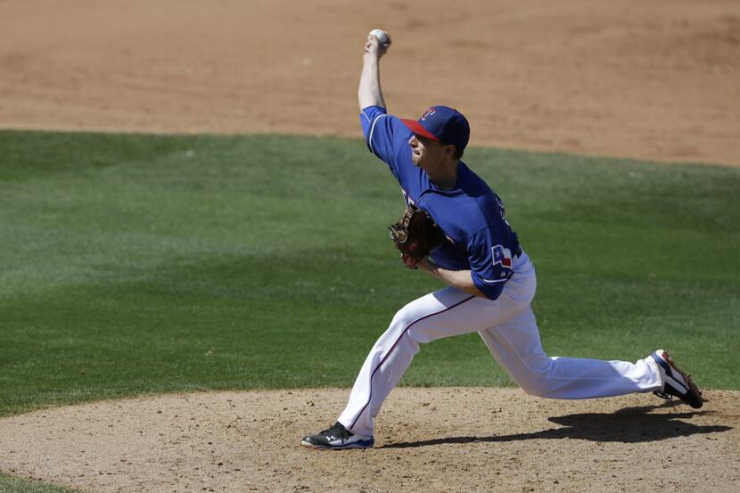 Texas Rangers' Tanner Scheppers throws during a spring exhibition baseball game against the...