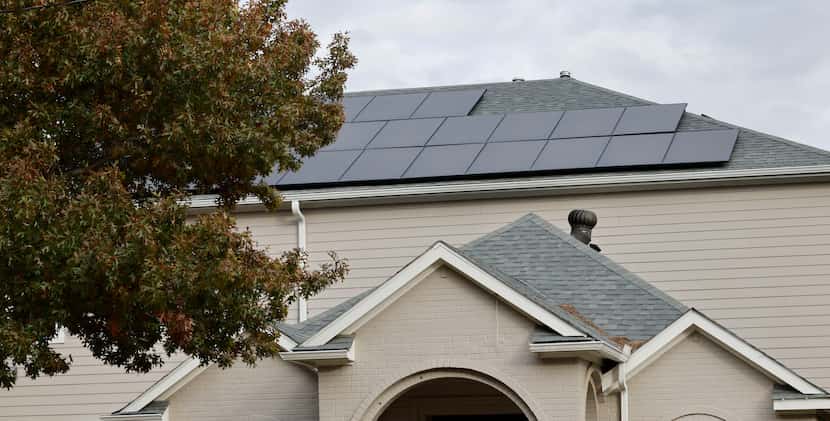 Solar panels are seen on the rooftop of Jesus Hernandez’s house in Irving. He signed a...
