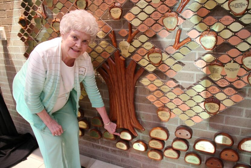 
Nita Patrick places a plaque on the Perpetual Giving Tree for the Nita Patrick Fine Arts...