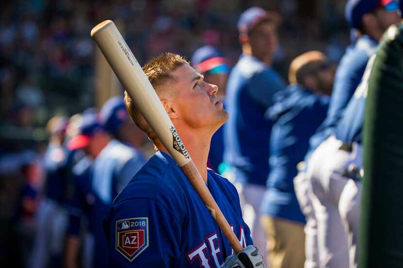 Texas Rangers outfielder Scott Heineman picks up a bat in the dugout before hitting during...