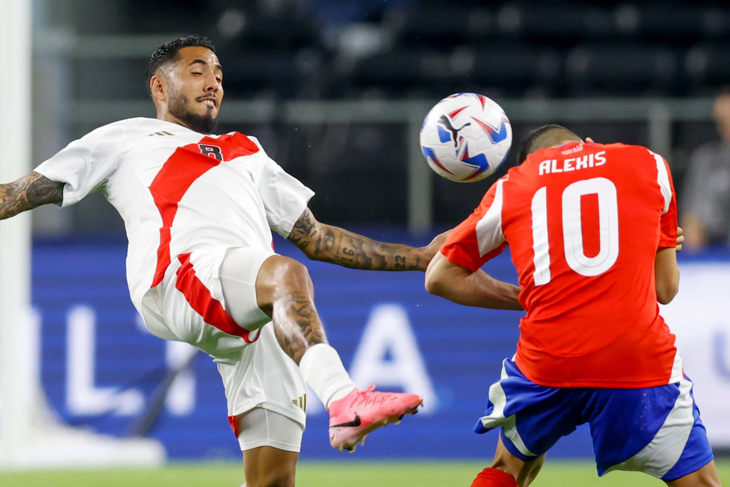 Peru midfielder Sergio Peña (8) tries to kick the ball as Chile forward Alexis Sánchez (10)...