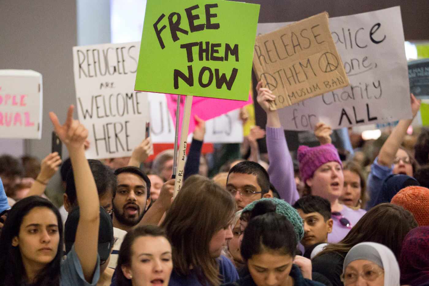 Protestors at DFW International Airport chant Sunday in opposition to President Donald...