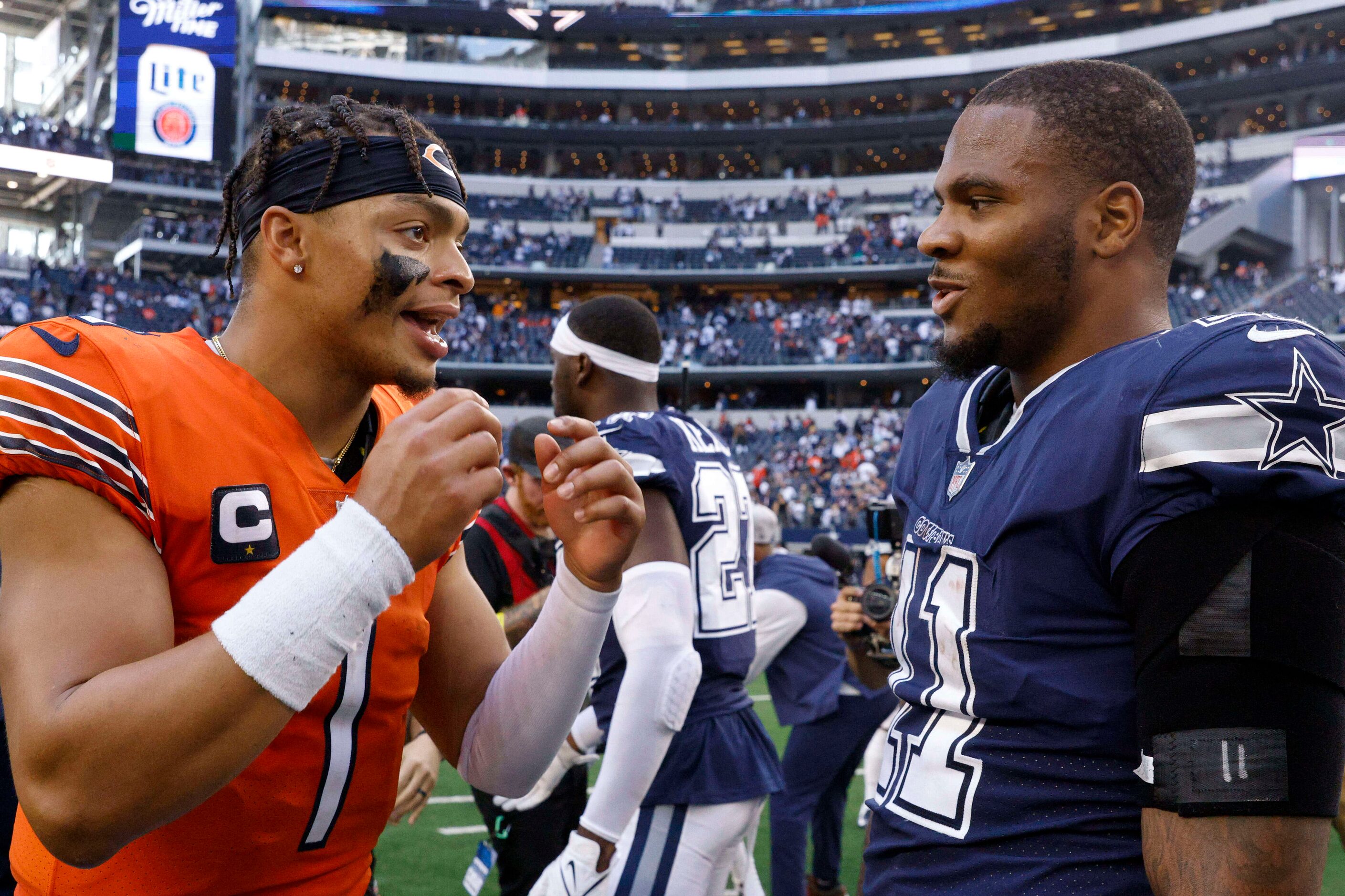 Chicago Bears quarterback Justin Fields (1) talks with Dallas Cowboys linebacker Micah...